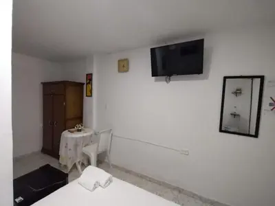 a room with a table and a tv on a wall at HABITACION CERCA DE LA UNIVERSIDAD DEL SINu in Cartagena de Indias