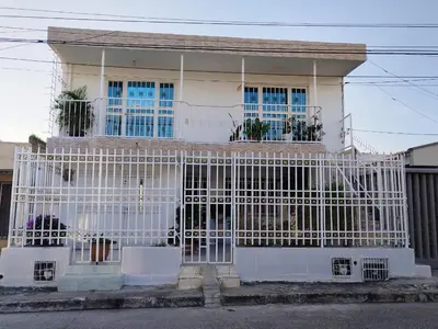a white house with a gate in front of it at HABITACION CERCA DE LA UNIVERSIDAD DEL SINu in Cartagena de Indias
