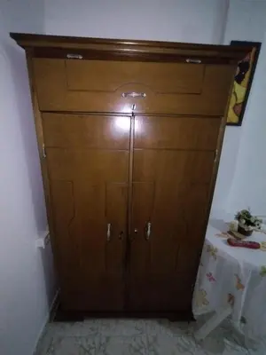 a large wooden cabinet in a room with a table at HABITACION CERCA DE LA UNIVERSIDAD DEL SINu in Cartagena de Indias