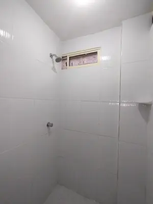 a white bathroom with a shower and a window at HABITACION CERCA DE LA UNIVERSIDAD DEL SINu in Cartagena de Indias