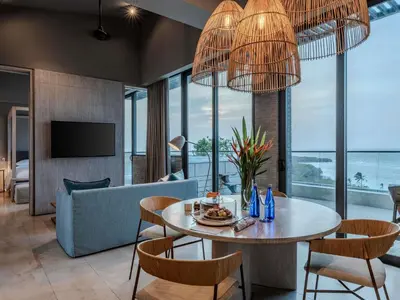 a living room with a table and chairs and a couch at Sofitel Barú Cartagena in Cartagena de Indias
