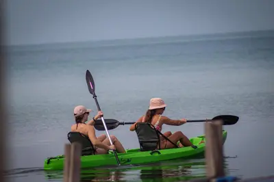 two women in a green kayak on the water at Santa Lova Eco-hostel Isla Tintipan in Tintipan Island