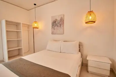 a bedroom with a white bed and two lights at Kpré Coveñas by Bernalo Hotels in Coveñas