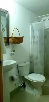 a white bathroom with a toilet and a sink at Cabañas La Cuchita RNT 61621 in Coveñas