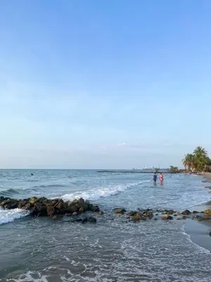 two people standing in the water at the beach at Manglearena in Tolú