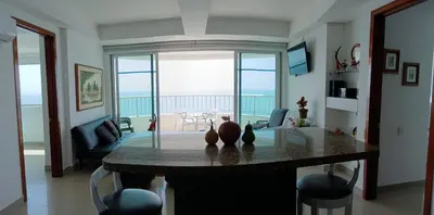 a living room with a table with a view of the ocean at Palmetto frente al mar 2603 in Cartagena de Indias