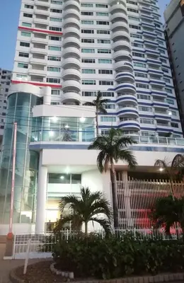 a large building with palm trees in front of it at Palmetto frente al mar 2603 in Cartagena de Indias