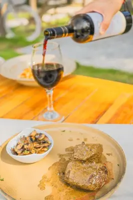 a person pouring a glass of wine and a plate of food at Vista Mare Beach House in Tierra Bomba