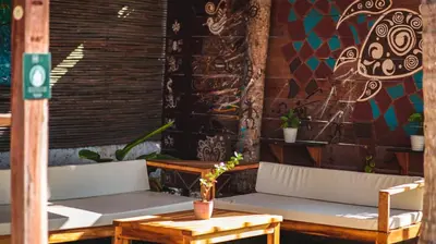 a porch with two white benches and a table at Vista Mare Beach House in Tierra Bomba