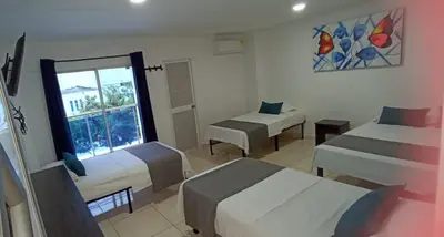 a hotel room with two beds and a window at Hotel La Inmaculada in Soledad