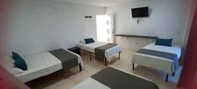 a hotel room with two beds and a television at Hotel La Inmaculada in Soledad