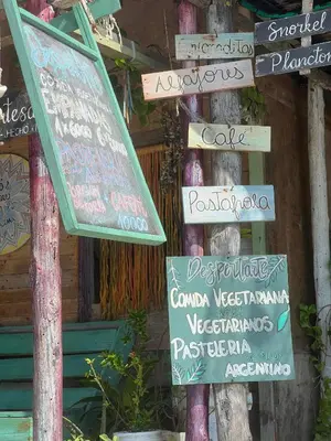 a group of signs on a pole in front of a building at DespertArte espacio de Arte y Hospedaje in Playa Blanca