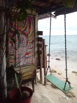 a swing on the beach with a painting of a woman at DespertArte espacio de Arte y Hospedaje in Playa Blanca