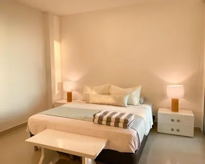 a bedroom with a bed with two lamps and a table at Vista al mar en Cartagena , Apartamento en Morros in Cartagena de Indias