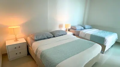 two beds in a room with two lamps and a night stand at Vista al mar en Cartagena , Apartamento en Morros in Cartagena de Indias