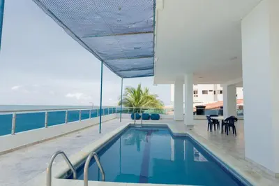 a swimming pool on the roof of a building with the ocean at APARTAMENTO MARINARE DE 2 HABITACIONES CON SALIDA DIRECTA A LA PLAYA in Cartagena de Indias