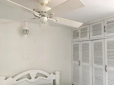 a ceiling fan in a white room with a closet at PLAYA LAGUITO in Cartagena de Indias