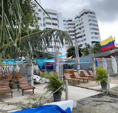 a row of wooden chairs sitting next to a pool at PLAYA LAGUITO in Cartagena de Indias
