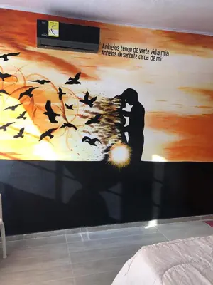 a wall with a mural of a man and birds at Casa Hotel Alborada in San Antero