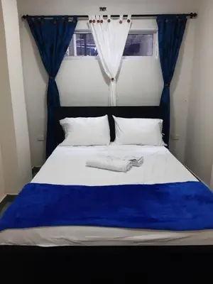 a bedroom with a blue and white bed with a window at Casa Hotel Alborada in San Antero