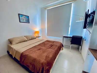 a bedroom with a bed and a desk and a window at La palma- casa amoblada Palma Mayorca in Sincelejo