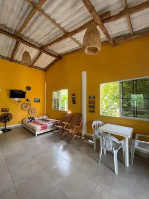 a room with a table and chairs and a bed at Cabaña cerca al mar - A 200 mts in Coveñas