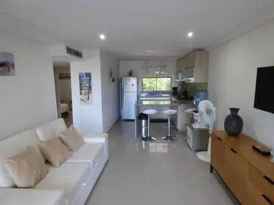 a living room with a white couch and a kitchen at Puesta del sol in Santa Marta