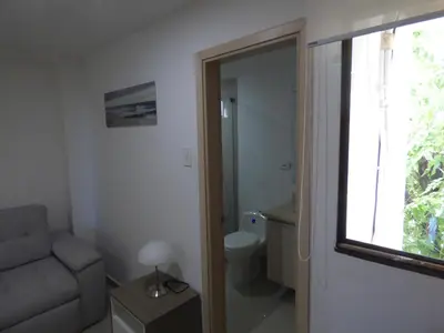 a bathroom with a toilet and a couch and a window at Puesta del sol in Santa Marta