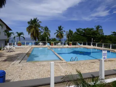 a large swimming pool with the ocean in the background at Puesta del sol in Santa Marta