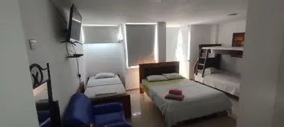 a small room with two beds and a blue chair at hotel interamericano in Barranquilla