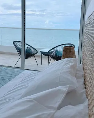 a bed with two chairs and a view of the ocean at Deluxe Spectacular Sunset in Santa Marta