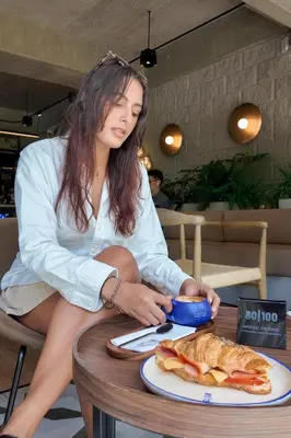 a woman sitting at a table with a plate of food at Mosaic Studios Buenavista in Barranquilla
