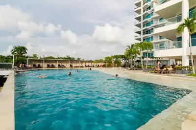 a pool at a resort with people in the water at Paraíso en Cartagena Confort Privado con Amenidades de Hotel in Cartagena de Indias