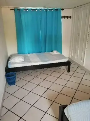 a room with a blue shower curtain on a tiled floor at Hospedaje Altamira in Barranquilla