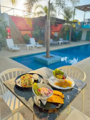 a table with plates of food on it next to a pool at Hotel Coco Beach by Croma in Cartagena de Indias
