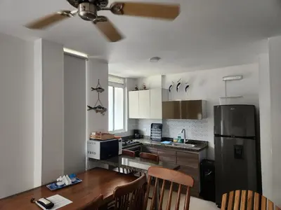 a kitchen with a refrigerator and a table and chairs at Loft 39 Casa de playa in Coveñas