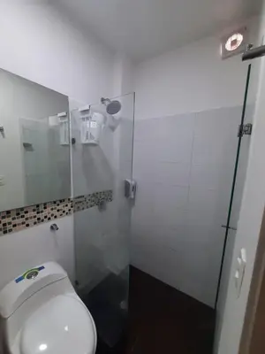 a bathroom with a toilet and a glass shower at Loft 39 Casa de playa in Coveñas