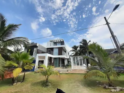 a house with palm trees in front of it at Loft 39 Casa de playa in Coveñas