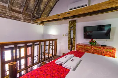 a bedroom with a bed and a tv on the wall at Casa Cordoba Román in Cartagena de Indias