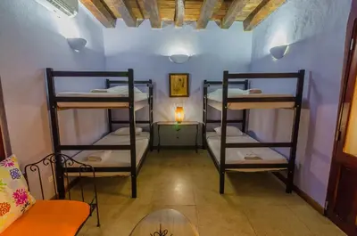 two bunk beds in a room with a table at Casa Cordoba Román in Cartagena de Indias