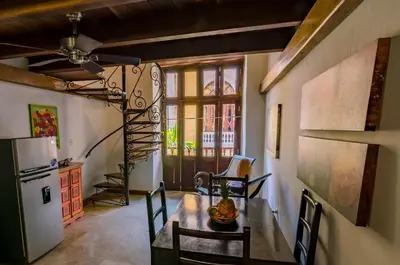 a dining room with a table and a refrigerator at Casa Cordoba Román in Cartagena de Indias