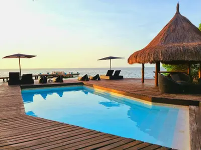 a swimming pool on the beach with chairs and umbrellas at Casa Cordoba Baru in Baru