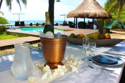a table with a bottle of wine in a bucket at Casa Cordoba Baru in Baru