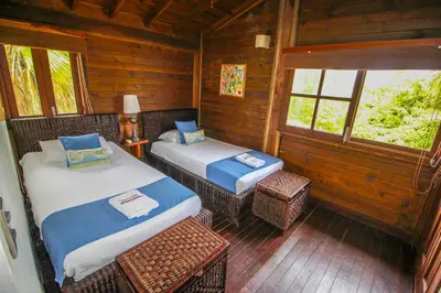 a room with two beds in a log cabin at Casa Cordoba Baru in Baru