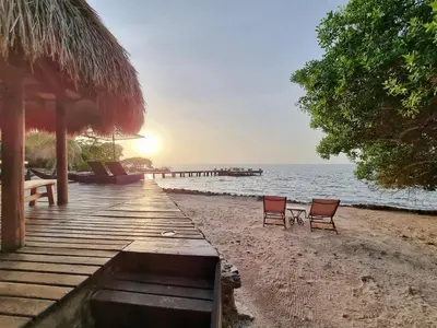 a beach with two chairs and a dock with the ocean at Casa Cordoba Baru in Baru