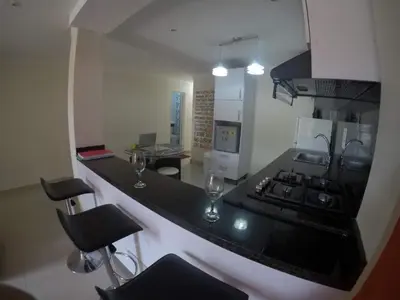 a kitchen with a black counter with two wine glasses at La casita de max y tim apt 201 in Cartagena de Indias
