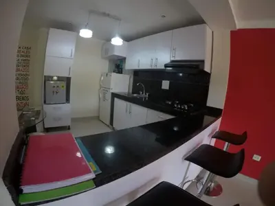 a kitchen with white cabinets and a black counter top at La casita de max y tim apt 201 in Cartagena de Indias