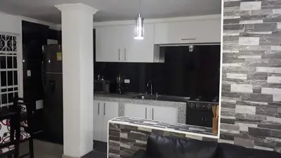 a kitchen with white cabinets and a stone wall at La casita de max y tim apt 202 in Cartagena de Indias