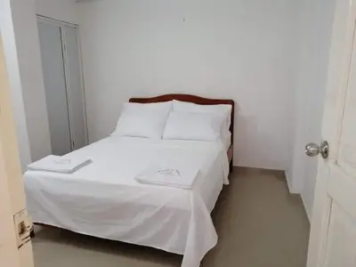 a bed with white sheets and pillows in a room at La casita de max y tim apt 202 in Cartagena de Indias