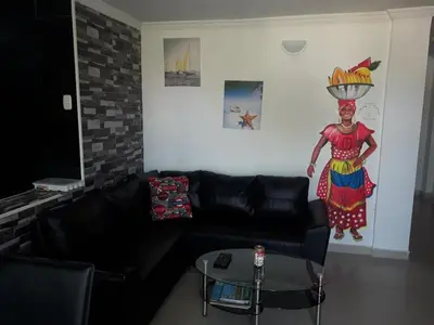 a living room with a black couch and a painting on the wall at La casita de max y tim apt 202 in Cartagena de Indias